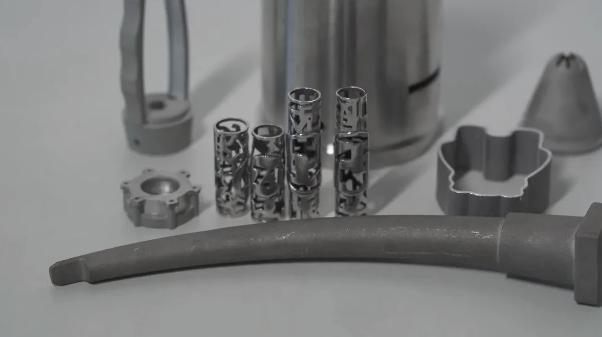 Various metal components 3D printed using powder bed fusion technology, showcasing intricate lattice structures.